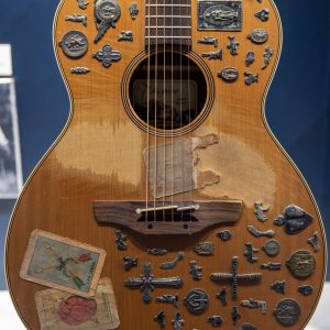 One of Bruce Springsteen's acoustic guitars featured in the exhibit. Decorated with around 30 small metal trinkets.
